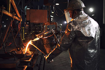 Pouring hot iron in foundry. Industrial steel production and casting.